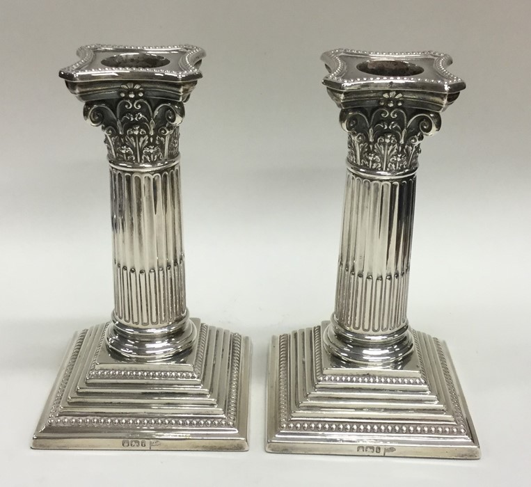 A good pair of Corinthian column silver candlestic