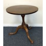 An oak tripod table on spreading feet. Est. £40 -