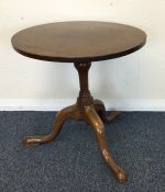 An oak tripod table on spreading feet. Est. £40 -