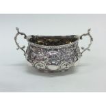 A Victorian style embossed silver two handled suga