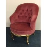 A button back nursing chair in pink upholstery wit