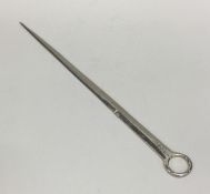 A large silver meat skewer with crested terminal.