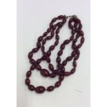 A double string of red amber beads. Approx. 64 gra