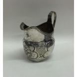 A Georgian silver embossed cream jug. London. By R