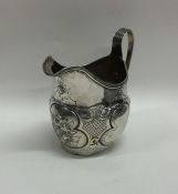 A Georgian silver embossed cream jug. London. By R