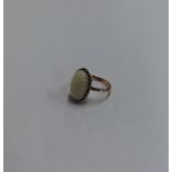 An opal single stone ring in gold claw mount. Appr