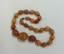 A tapering string of amber beads with barrel clasp