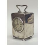 A miniature silver carriage clock with white ename