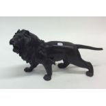 A bronzed model of a lion in standing position. Es