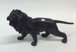 A bronzed model of a lion in standing position. Es