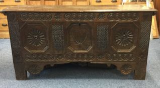 A large oak hinged top coffer with floral decorati