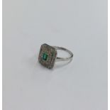 An Art Deco emerald and diamond cluster ring with