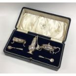 A cased silver three piece cruet set of baluster f