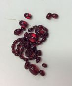 A graduated string of red amber type beads of tape