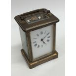 A small brass mounted carriage clock with white en