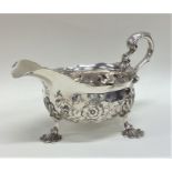 A Georgian silver embossed sauce boat decorated wi