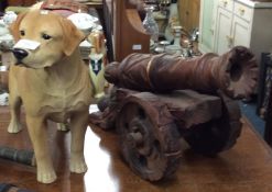 A resin model of a Labrador together with a wooden canon.