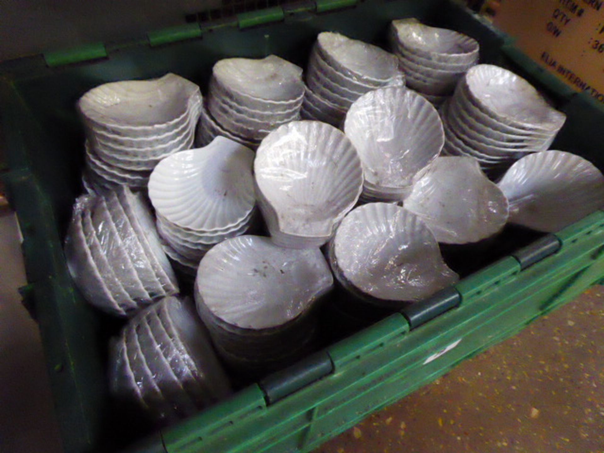 Plastic stacking crate containing approx. 230 scallop shape dishes