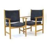 A pair of 1970's oak framed elbow chairs with navy blue upholstery,