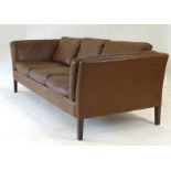 A 1970's Danish brown leather three-seater sofa on square tapering feet, l.