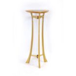 A beech and walnut strung plant stand with a circular glazed insert on three splayed legs,