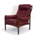 A 1970's Swedish armchair, the stained beech frame with red button upholstery,