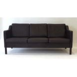 A 1970's Danish dark brown leather three-seater sofa on square straight feet,