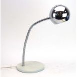 An Italian desk lamp, the chromed shade on an adjustable shaft and white circular base,