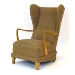 A 1950/60's wingback button upholstered armchair with beech arms,