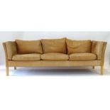 A Stouby tan leather three-seater sofa on square beech feet, l.