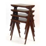 A set of four walnut and crossbanded stacking side tables on compass legs,