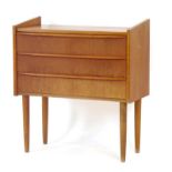 A 1970's Danish teak chest of three drawers with raised gallery sides and turned legs, w.