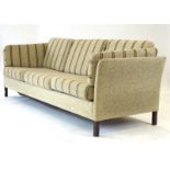 A Danish 1970's cloth three-seater sofa on square mahogany feet, l.