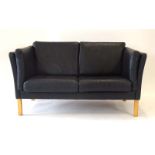 A Danish 1970's black leather two-seater sofa on square beech feet, l.