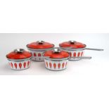 A set of four Norwegian orange and white enamelled 'Lotus' saucepans by Catherine Holm