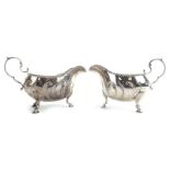 A pair of Victorian silver sauce boats of typical form with leaf capped c-scroll handles on hoof