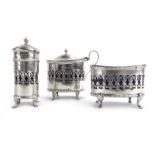 An early 20th century silver three piece pierced silver cruet set of boat/cylindrical form,