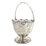 A pierced silver basket, the swing handle above a foliate base of ovoid form, maker RWB,