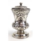 A William IV silver pepper of vase shaped form repousse decorated in the Neo-Classical manner,