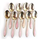 A set of nine silver and parcel gilt spoons decorated in a pale pink enamel,