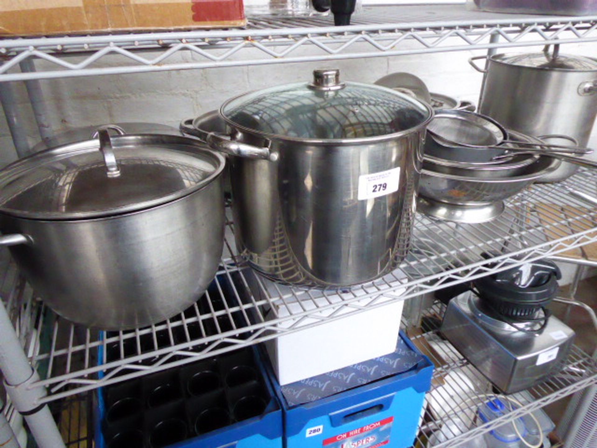 Shelf of stainless steel and aluminium cookware, stock pots, colanders, etc