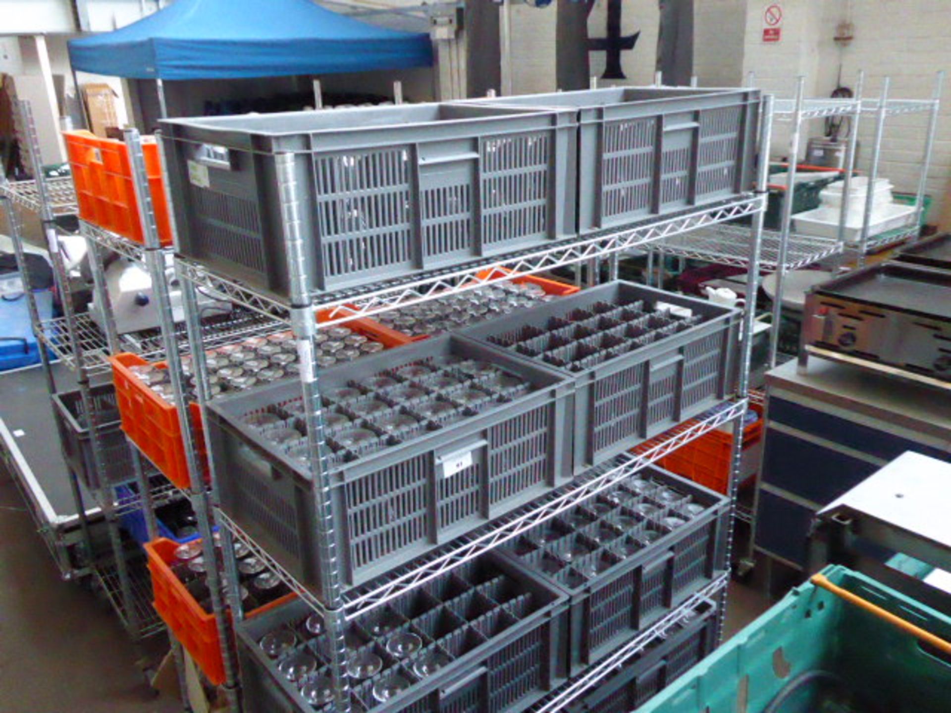 Eight grey stacking crates containing a large quantity of wine glass