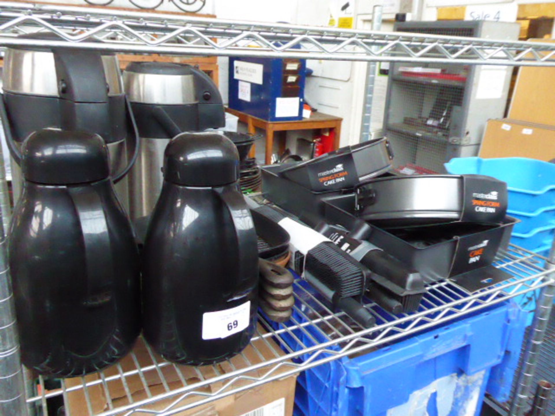 Shelf of flasks, griddles, rubber brooms and cake pans