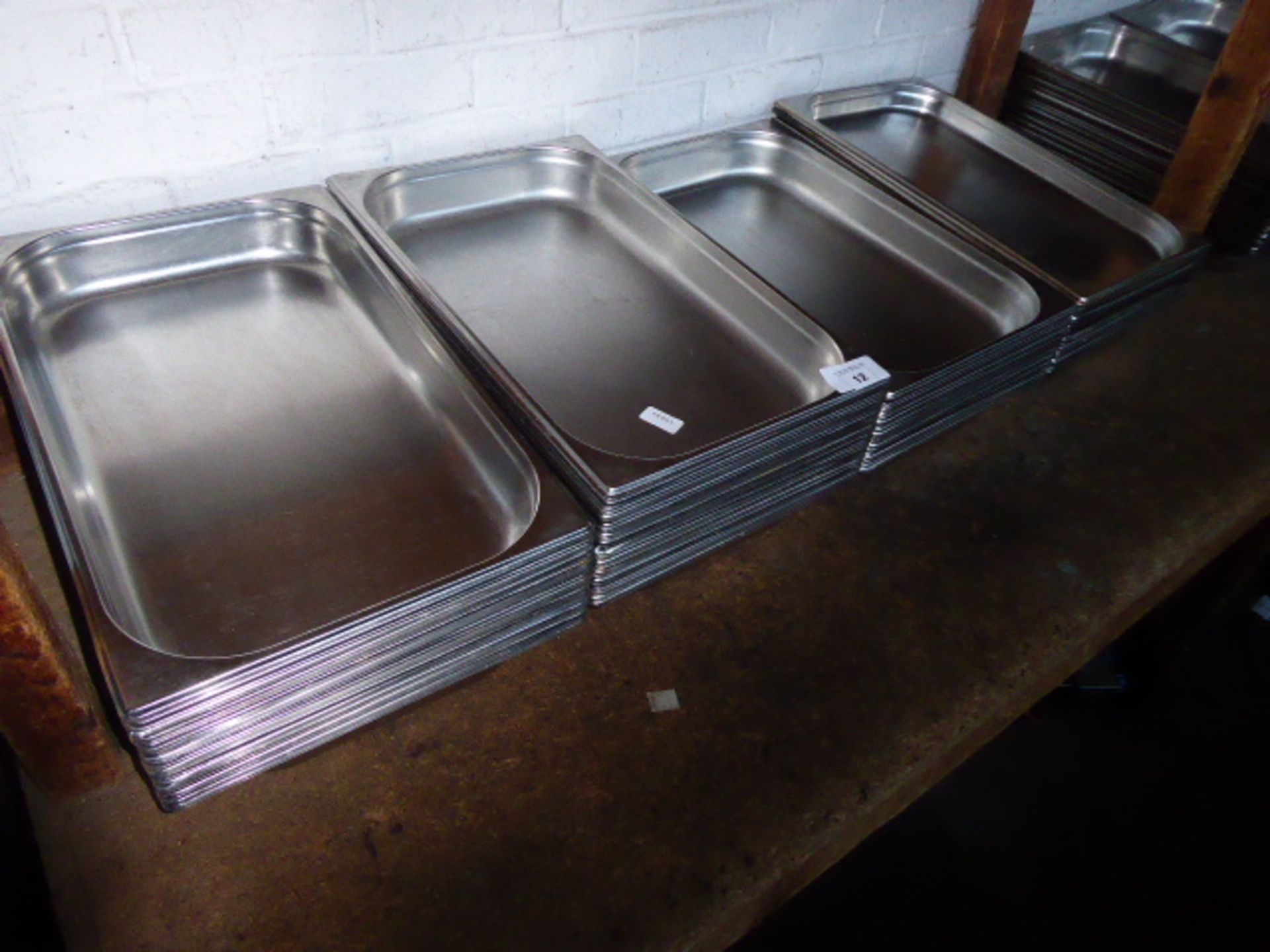 Approximately eighty stainless steel shallow Gastronorm pans