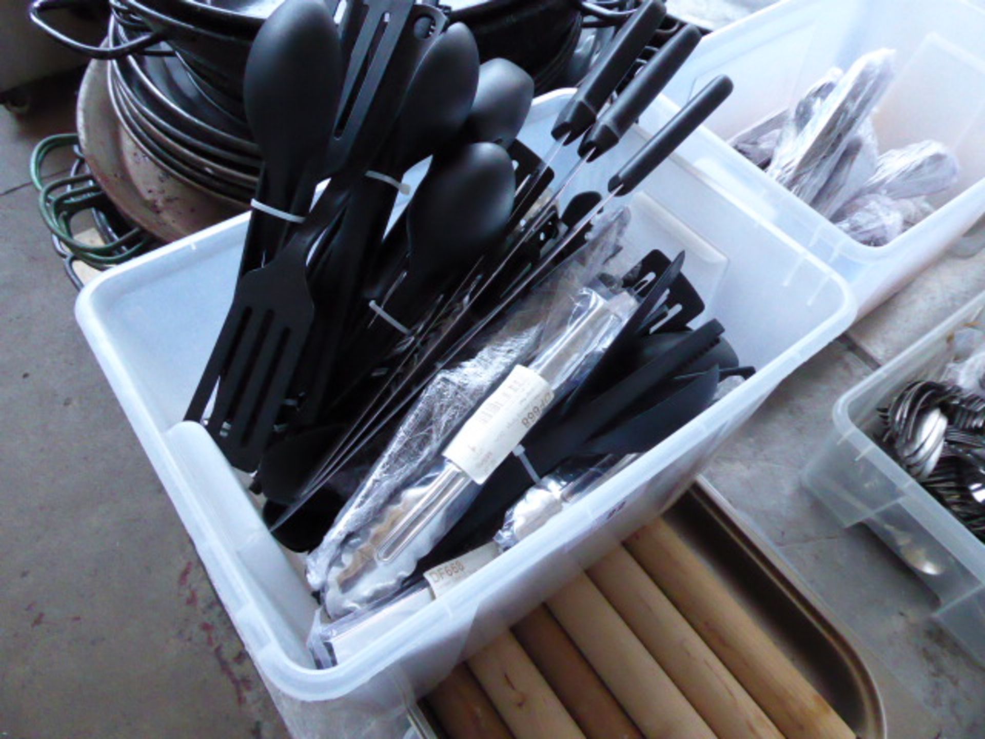 Large box of assorted plastic and metal cooking utensils and a tray of rolling pins