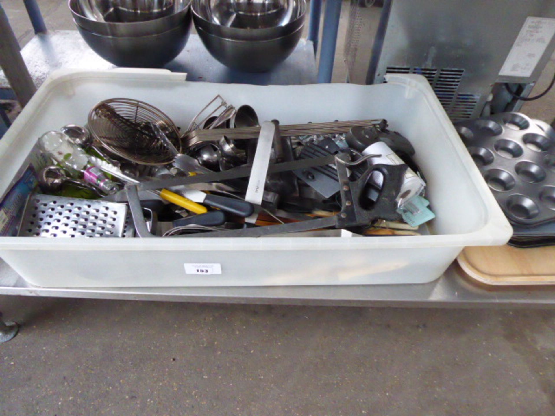 Large plastic tray containing various chef's utensils and butchery utensils