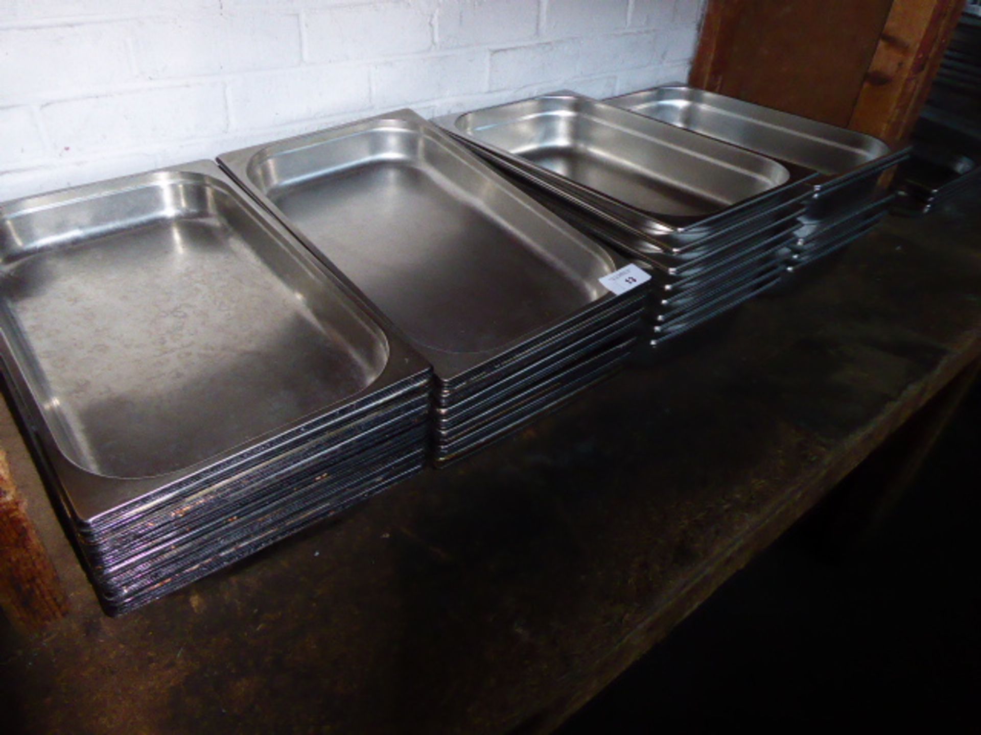 Approximately sixty stainless steel shallow Gastronorm pans