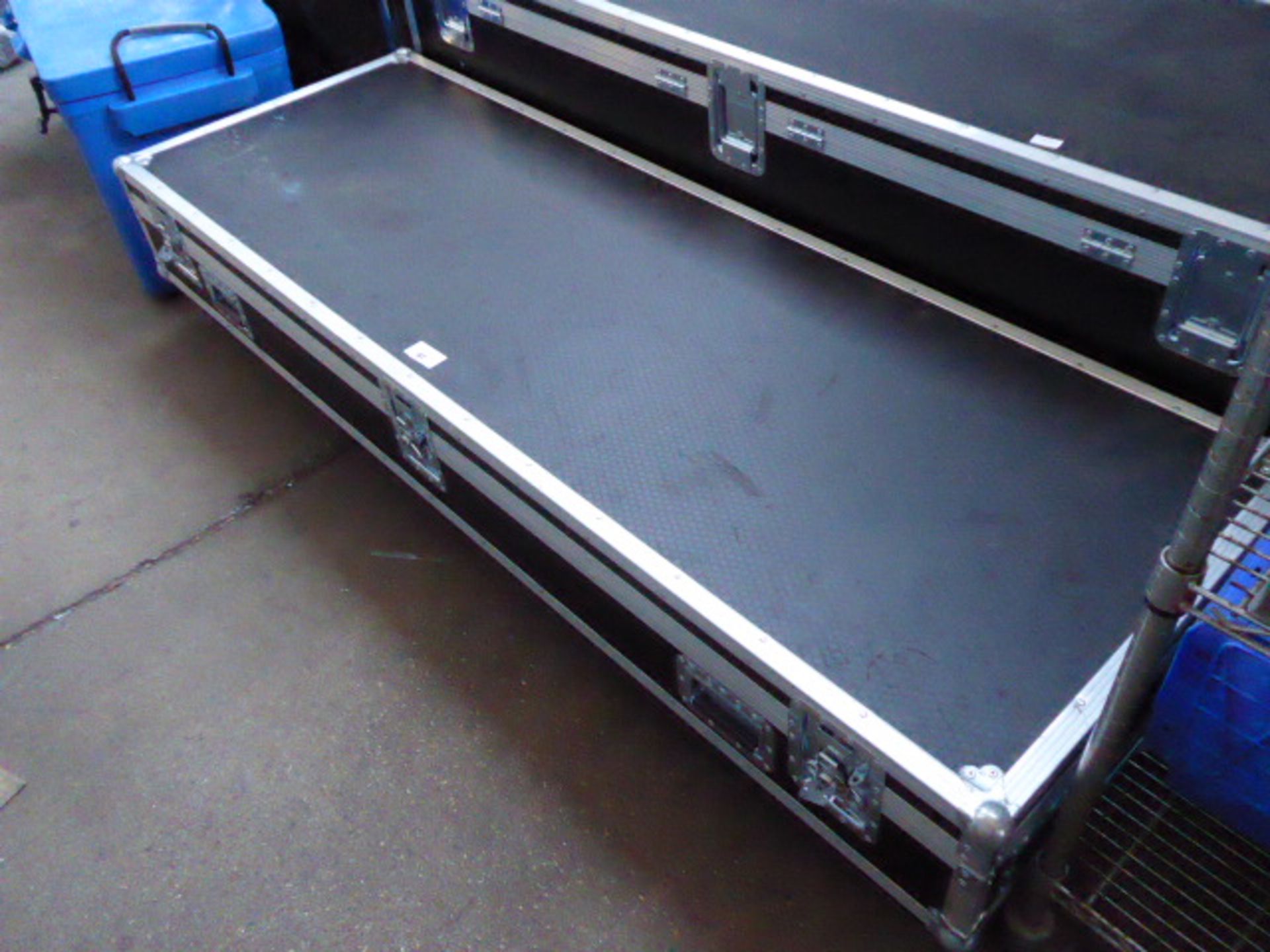 Two large aluminium bound transport cases on castors measuring 200cm by 70cm containing a quantity