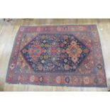 An early 20th century rug, the three medallions within a red and blue ground and matching borders,
