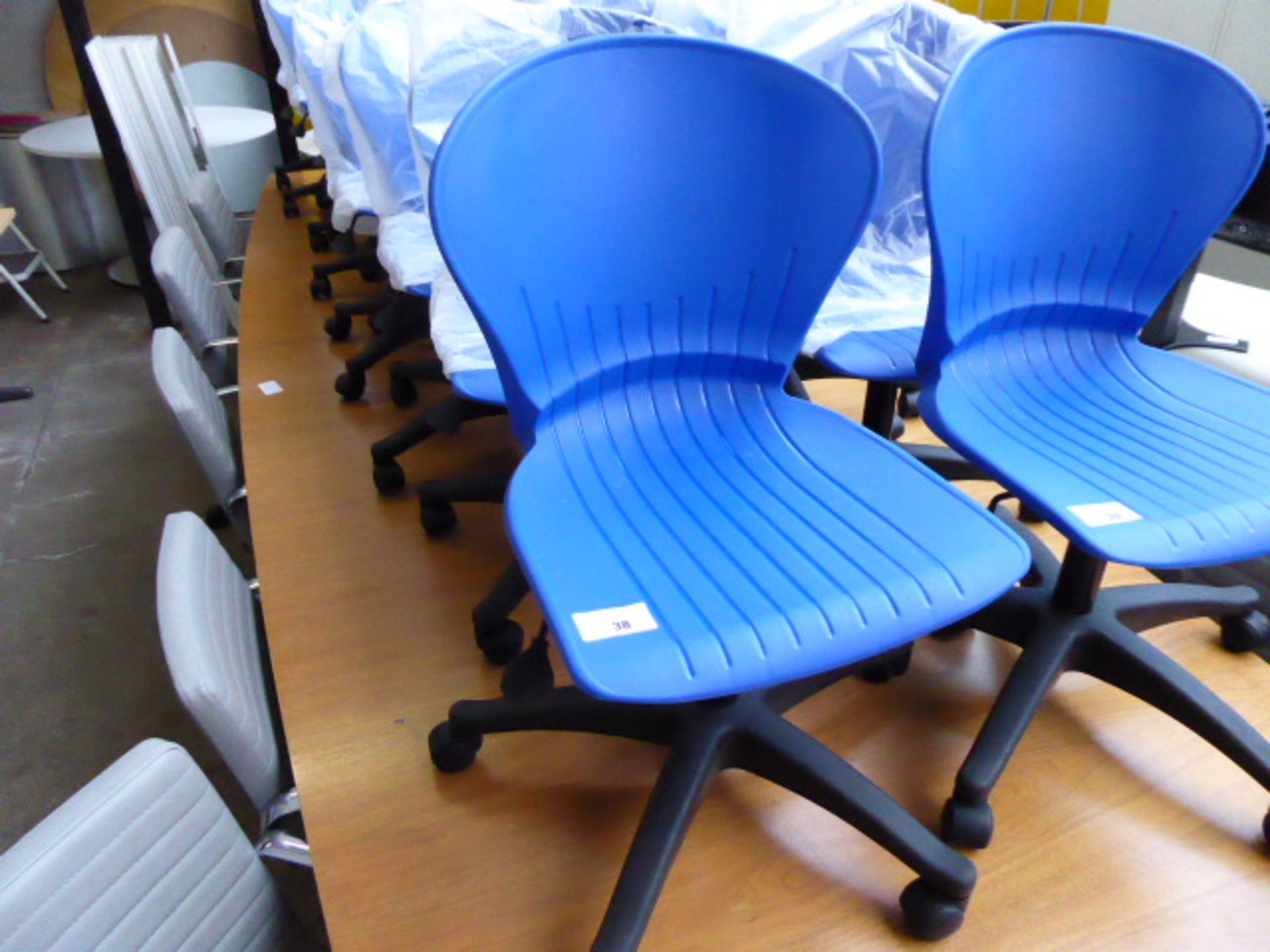 Ten blue plastic seated and black base swivel chairs